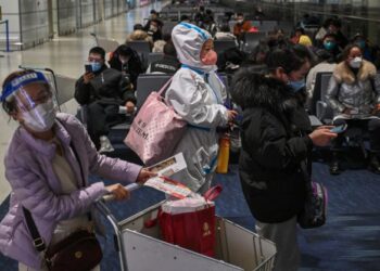 KELIHATAN penumpang memakai sut peralatan perlindungan diri (PPE) sebelum berlepas penerbangan domestik di Lapangan Terbang Antarabangsa Shanghai Pudong baru-baru ini.-AFP