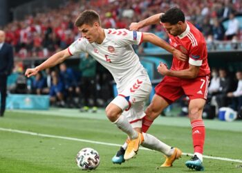 PEMAIN pertahanan Denmark, Joakim Maehle diasak pemain tengah Rusia, Magomed Ozdoev. Joakim menjaringkan satu gol untuk Denmark yang menang 4-1 menentang Rusia. - AFP