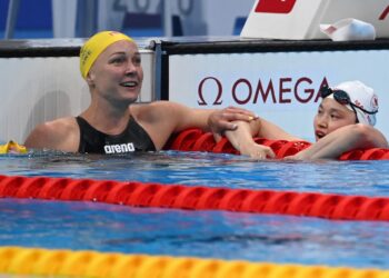 Sarah Sjoestroem (kiri) memberi reaksi teruja kepada Margaret Macneil selepas perenang Kanada itu meraih pingat emas dalam acara 100m kuak kupu-kupu.