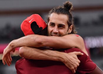 PEMENANG emas, Gianmarco Tamberi (kanan) memeluk 'rakan kongsinya' Mutaz Essa Barshim selepas masing-masing menggondol emas dalam acara lompat tinggi di Sukan Olimpik 2020 Tokyo.- AFP