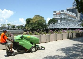 PEKERJA memandu mesin pembersihan jalan di Singapura. Kadar pemberhentian pekerja di Singapura melonjak tinggi ekoran kesan Covid-19. - AFP