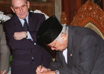 Suharto menandatangani Letter of Intent Dana Kewangan Antarabangsa (IMF) pada 15 Januari 1998 sambil diperhatikan Michael Camdessus. – AFP