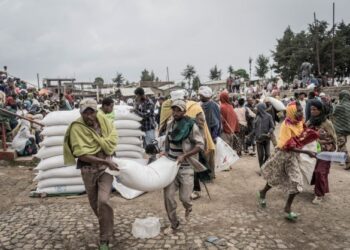 PELARIAN yang melarikan diri dari peperangan di May Tsemri, Addi Arkya dan Zarima menunggu giliran mendapatkan bungkusan gandum dari Program Makanan Dunia di Gondar, Ethiopia.-AFP