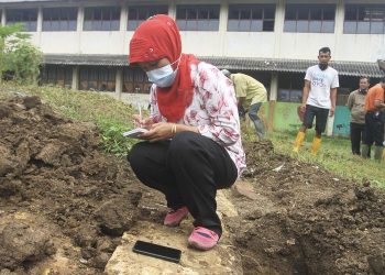 AHLI arkeologi mengkaji penemuan batu candi yang dipercayai dari abad ke-12 di Daerah Ilir Timur II Palembang. - KOMPAS.COM/AJIK YK PUTRA