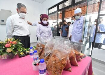 NANCY Shukri (tengah) melihat serunding di Laman Warisan Serunding Kampung Laut sambil diperhatikan Mustapa Mohamed (kiri) dan Ahmad Yakon di Kampung Laut, Tumpat, hari ini. - UTUSAN/ROSLIZA MOHAMED