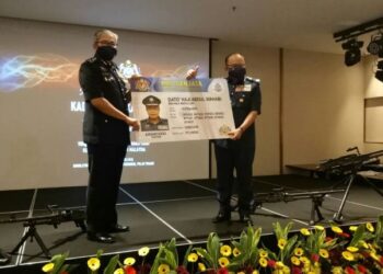 MAZLAN Lazim (kiri) menyerahkan replika kad senjata JKDM kepada Abdul Latif Abdul Kadir dalam sidang akhbar Operasi Bersepadu Khazanah (OBK) di Tanjung Bungah, Pulau Pinang hari ini.