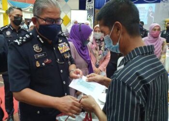 MAZLAN Lazim beramah mesra dengan seorang pesara PDRM, Rosmadi Mohamad pada majlis penyampaian bantuan zakat kepada asnaf, balu, anak yatim dan pesara polis di Markas Pasukan Polis Marin Wilayah 1, Batu Uban, Pulau Pinang hari ini.