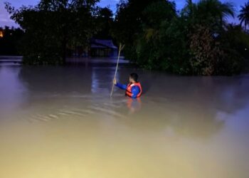 ANGGOTA APM memeriksa bagi mengenal pasti sekiranya masih terdapat mangsa banjir yang terperangkap di Kampung Beringin, Alor Gajah, Melaka.