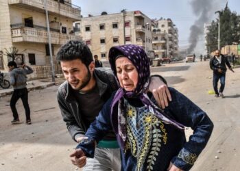 ORANG ramai menyelamatkan diri ketika serangan berlaku di bandar Afrin, utara Syria pada Mac 2018. - AFP