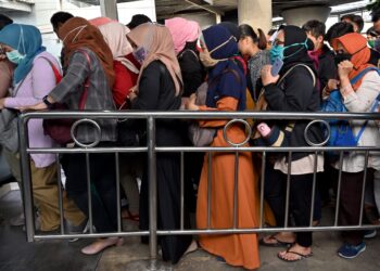 ORANG ramai bersesak-sesak dan tidak menjaga penjarakan fizikal ketika menaiki tren di Stesen Tanah Abang, Jakarta. - AFP