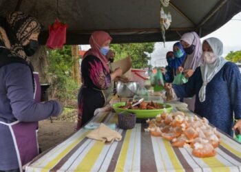 NURUL Ain Azmi (dua, dari kiri) melayan pelanggan yang membeli nasi bajet di gerainya di Pengadang Baru, Kuala Terengganu, Terengganu. - UTUSAN/PUQTRA HAIRRY ROSLI