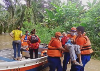 ANGGOTA APM menjalankan operasi pemindahan mangsa banjir di Telupid.-IHSAN APM