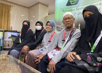 YUSOFF (dua dari kanan) dan Saedah (tiga dari kiri) bergambar bersama tiga anaknya yang menjadi pengiring untuk mereka menunaikan ibadat haji ketika ditemui di Abraj Al-Janadriyah di Mekah baru-baru ini.