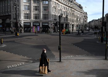 SEORANG wanita memakai pelitup muka semasa berjalan di Oxford Circus di London. -AFP