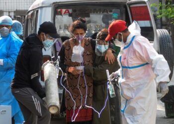 SEORANG pesakit Covid-19 yang bernafas dengan bantuan silinder oksigen tiba di sebuah hospital di Kathmandu, Nepal untuk mendapatkan rawatan. - AFP