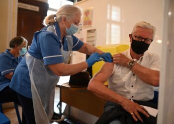 SEORANG penduduk menerima suntikan vaksin Covid-19 di sebuah pusat vaksinasi sementara di Dewan Bandaraya di Hull, timur laut England. - AFP