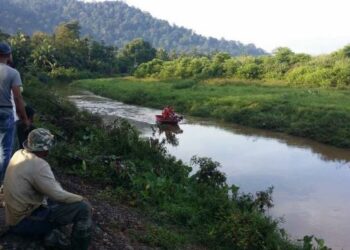 Pasukan mencari dan menyelamat menyusuri Sungai Perupok untuk mencari seorang kanak-kanak lelaki yang  dikhuatiri lemas di Kampung Perupok, Yan hari ini. - UTUSAN/OTHMAN YAHAYA