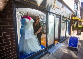 DEBBIE SHELLEY bersama patung pengantin bersaiz besar di butiknya di Minehead. -SWNS