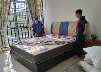 AISHAHTON Ismail  mengemas bilik tidur utama di rumah inap desanya yang ditempah pelanggannya sempena Hari Raya Aidilfitri di Kuala Terengganu. - UTUSAN/KAMALIZA KAMARUDDIN