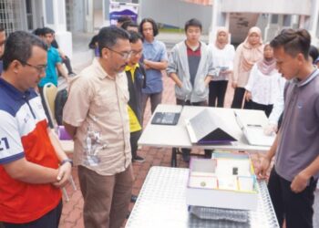 LUTFAN Jaes (tiga dari kiri) mendengar penerangan tentang peranan dan fungsi rumah terapung yang diperkenal kumpulan penuntut Kursus Kokurikulum Berkredit Pengurusan Kreativiti, UTHM, Johor.