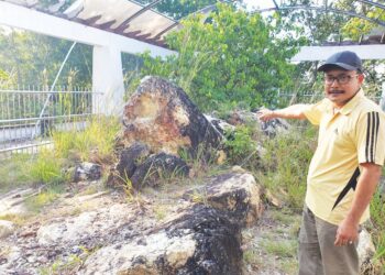 WAN Mohd. Rosli Wan Ngah menunjukkan keadaan di kawasan batu penyu yang terbiar di Bukit Che Hawa, Rantau Abang, Dungun, Terengganu. - UTUSAN/NIK NUR IZZATUL HAZWANI NIK ADNAN