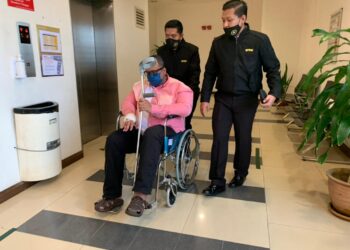 MOHAMED AL FAIZAL dibawa oleh pegawai SPRM menggunakan kerusi roda untuk menghadapi dua pertuduhan rasuah di Mahkamah Sesyen Shah Alam, Selangor hari ini. UTUSAN/NORHAYATI YAHAYA
