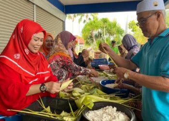 ROZIEANA Ahmad (kiri) bersama-sama penduduk terlibat menyiapkan anyaman ketupat sebelum direbus di dalam periuk menerusi Projek Balut Ketupat yang diadakan di Tambun Tulang, Arau, Perlis hari ini. -UTUSAN.