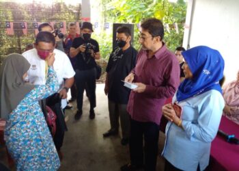 SALAH seorang mangsa ribut menerima sumbangan disampaikan oleh Zahidi Zainul Abidin (dua dari kanan) dalam satu majlis di Pusat Khidmat Mata Ayer, Padang Besar, Perlis hari ini. - UTUSAN/ASYRAF MUHAMMAD