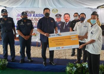 MOHD. Zuki Ali (tiga, dari kiri) menyampaikan replika cek dalam Majlis Jalinan Kasih Keluarga Malaysia, Program Khidmat Bakti Masyarakat di Sekolah Kebangsaan Bukit Bayas di Kuala Terengganu hari ini. - PUQTRA HAIRRY ROSLI