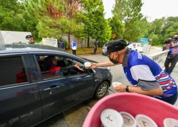 ABDUL AZIZ Abdul Rahman mengagihkan bubur lambuk kepada warga kampus di Universiti Malaysia Pahang (UMP), Pahang. - IHSAN UMP