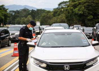 PEGAWAI polis memeriksa sebuah kereta di Lebuhraya Kuala Lumpur-Karak berdekatan Tol Gombak yang sesak dengan kenderaan menjelang 1 Syawal, baru-baru ini. – UTUSAN/AFIQ RAZALI