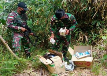 DUA anggota tentera Indonesia memeriksa dua kotak yang mengandungi pelbagai jenis ubat dipercayai cuba diseludup dari Malaysia di Sanggau, Kalimantan Barat. - AGENSI