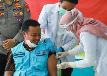 TIMBALAN Gabenor Sulawesi Selatan, Andi Sudirman Sulaiman merupakan individu pertama menerima suntikan itu di daerah berkenaan. - KOMPAS.COM