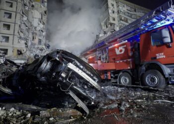 GAMBAR ini menunjukkan kenderaan yang remuk dan bangunan yang musnah dibedil peluru berpandu di Dnipro, Sabtu lalu.-AFP