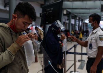 PENUMPANG melakukan ujian GeNose C19 sebelum menaiki kereta api di Stesen Pasar Senen, Jakarta, Indonesia. - AGENSI