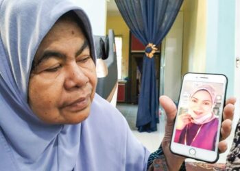 ZAHASNAH Mohd Zain (kiri) menunjukkan gambar Rosnazirah Mohd. Naim ketika ditemui di rumahnya di Kampung Semat Jal, Wakaf Bharu, Tumpat, Kelantan. - UTUSAN/ROHANA ISMAIL