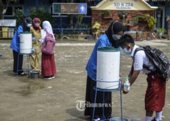 PELAJAR mencuci tangan sebelum mengikuti sesi pembelajaran bersemuka di Palembang. - TRIBUNNEWS