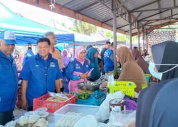 NAWI Mohamad (tiga dari kiri) beramah mesra dengan pengunjung dan peniaga ketika berkempen di Pasar Pagi Alor Lintah, Besut, Terengganu, baru-baru ini. - UTUSAN/KAMALIZA KAMARUDDIN