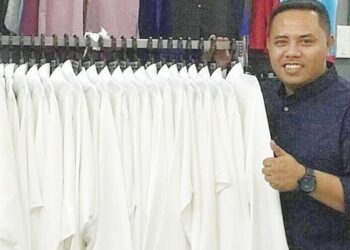 SHAHRIZAL Md. Sari menunjukkan baju Melayu yang siap untuk dijual sempena sambutan Hari Raya Aidilfitri di butiknya di Jalan Kebun, Klang, Selangor.