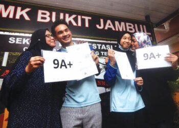 EMIR FALIQ LIM ADAM LIM (dua dari kiri) bersama ibunya, Zarina Mohamed Ibrahim dan Nur Aina Fadhlina Ahmad Fazli (dua kanan) bersama ibunya, Nor Dibradini Selamat menunjukkan keputusan cemerlang SPM 2021 di SMK Bukit Jambul, Pulau Pinang. - UTUSAN/IQBAL HAMDAN