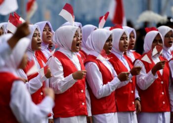 PELAJAR bersemangat menyanyikan lagu kebangsaan Indonesia di Blang Pidie, Aceh. - AFP