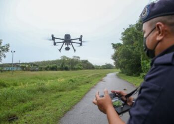 ANGGOTA Unit Dron Pasukan Gerakan Udara Polis Diraja Malaysia mengendalikan peralatan itu bagi memantau sempadan Malaysia-Thailand di Padang Besar, Perlis, baru-baru ini. – UTUSAN/SHAHIR NOORDIN