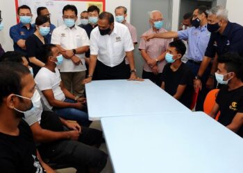 Menteri Sumber Manusia, Datuk Seri M. Saravanan (berdiri, tengah) beramah mesra dengan pekerja asing ketika melawat Asrama Pekerja Taman Perindustrian Maju Cemerlang, Ulu Tiram, Johor, baru-baru ini. 
– UTUSAN/RAJA JAAFAR ALI