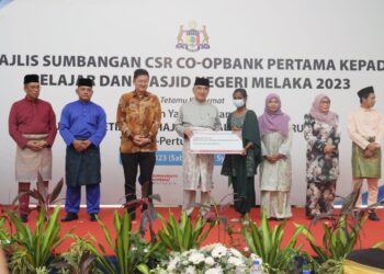 MOHD. Ali Rustam (empat dari kanan) menyampaikan sumbangan kepada penerima pada Majlis Sumbangan CSR Co-opbank Pertama kepada Pelajar dan Masjid Negeri Melaka 2023 di Melaka.