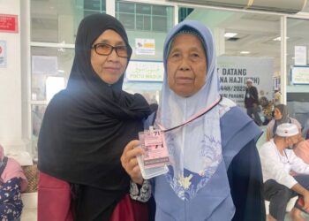 PARINAH Dolah (kanan) teruja dapat mengerjakan ibadah haji selepas mendaftar dengan Tabung Haji 15 tahun lalu. - UTUSAN/NORHAFIZAN ZULKIFLI