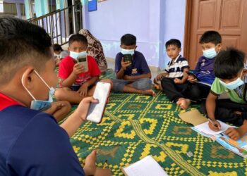 Sebahagian murid-murid belajar secara dalam talian dengan menggunakan telegon bimbit di Surau As Shakirin, Pontian Besar. – UTUSAN