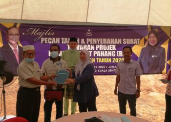 Pengerusi Jawatankuasa Perpaduan, Kebajikan Masyarakat, Pembangunan Wanita dan Keluarga negeri, Datuk Seri Shahaniza Shamsuddin (dua kanan) menyampaikan surat tawaran projek Rumah Rakyat Pahang (RRP) kepada seorang penerima di Kampung Kuala Sentol, Maran pada 26 September 2020.