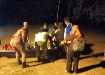 PASUKAN penyelamat membantu sebahagian 20 mangsa yang terperangkap selepas rumah dan jalan utama dinaiki air di Kampung Semalou, Endau, Mersing, Johor, hari ini. - IHSAN BOMBA