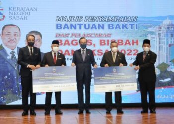 MASIDI Manjun (tengah) menyampaikan peruntukan Bakti kepada wakil JPNS dan Jheains di Menara Kinabalu hari ini.