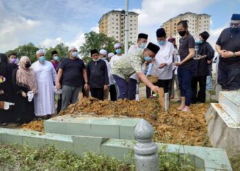 HASNI Mohammad menyiram air mawar ke atas pusara Allahyarham Mohamad Aziz yang dikebumikan di Tanah Perkuburan Bukit Aliff, Johor. - UTUSAN/KHAIRUL MOHD ALI